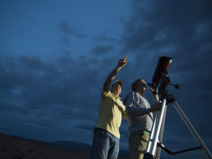 Couple using telescope on tripod. Date : 2007