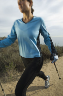Hispanic woman pole walking along coast in California, United States. Date : 2007