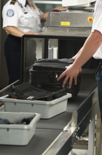 Airport security worker checking baggage. Date : 2007