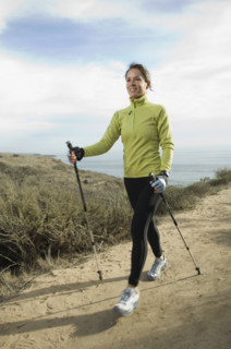 Hispanic woman pole walking along coast in California, United States. Date : 2007