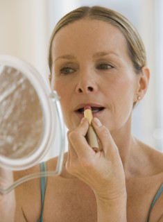 Woman applying lipstick.