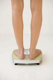 Woman standing on scale.
