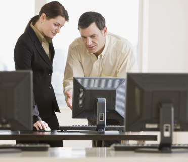 Businesspeople looking at computer.