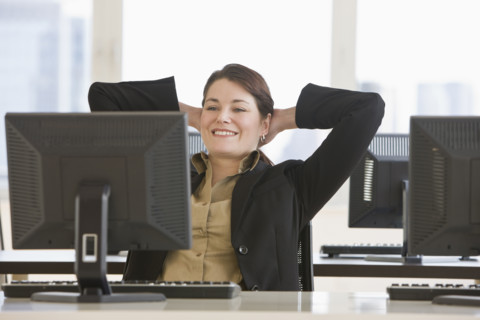 Businesswoman with hands behind head.