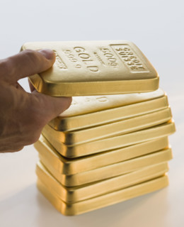 Man picking up gold bar.