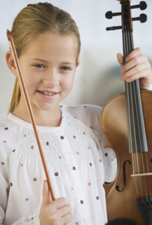 Girl holding violin and bow.
