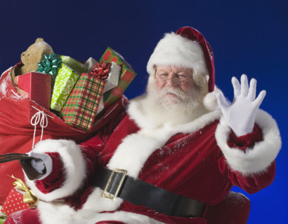 Santa Claus next to bag of toys.