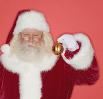 Santa Claus holding Christmas ornament.