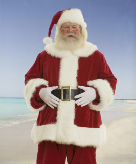 Santa Claus laughing at beach.