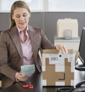 Businesswoman opening package.