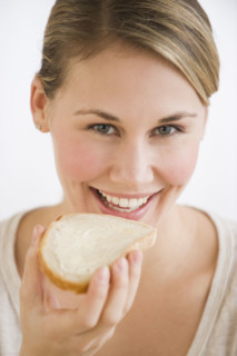 Woman eating bread and butter.