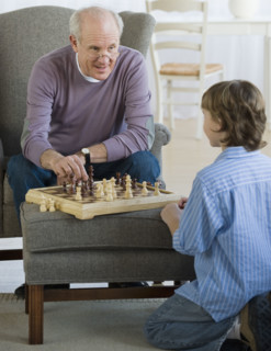 Grandfather and grandson playing chess.