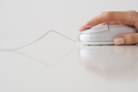 Woman’s hand on computer mouse.