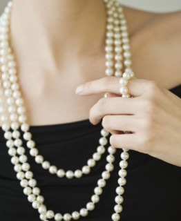 Woman wearing strands of pearls.