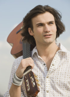 Man holding guitar on shoulder.