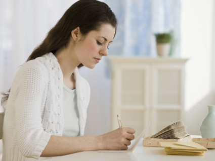 Woman writing at table.