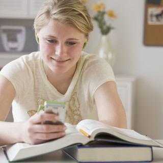 Teenaged girl looking at mp3 player.