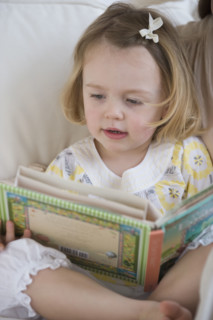 Young girl looking at book.