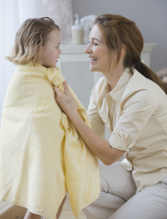 Mother drying daughter with towel.