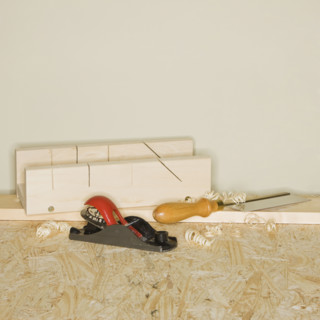 Woodworking plane and awl next to wood blocks.