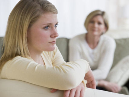Teenaged girl looking away from mother.