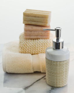 Stack of soap and towels next to lotion.