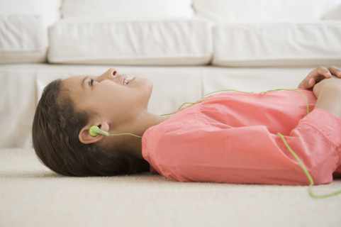 Hispanic girl listening to headphones.