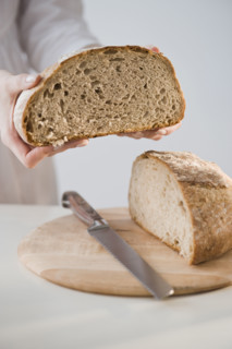 Woman holding loaf of bread.