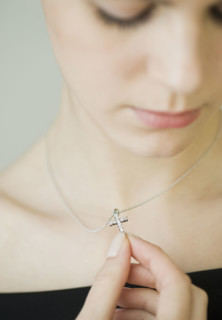 Woman wearing cross necklace.