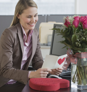 Businesswoman reading Valentine’s Day card.