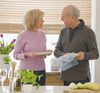 Senior couple drying dishes.