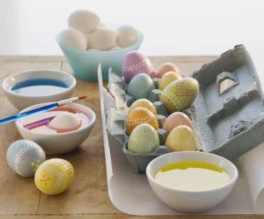 Decorated eggs next to bowls of dye.