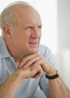 Senior man resting chin on hands.