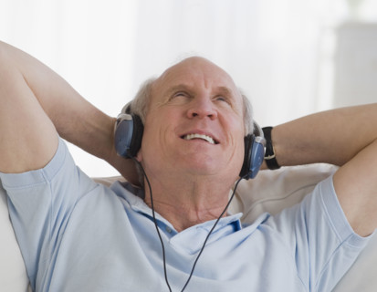 Senior man listening to headphones.