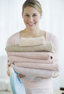 Woman holding folded towels.