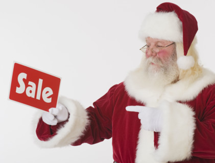 Santa Claus holding Sale sign.