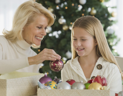Grandmother and granddaughter looking at Christmas ornaments.