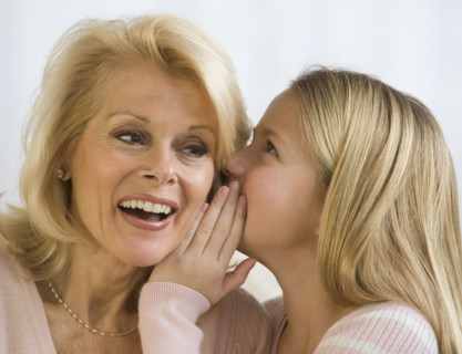 Grandmother and granddaughter telling secret.