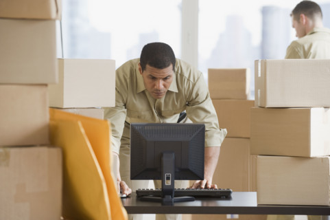 African delivery man looking at computer.