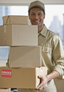 African delivery man carrying stack of packages.