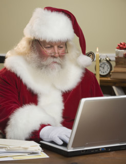 Santa Claus looking at laptop.