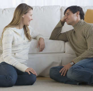 Couple sitting on floor talking.