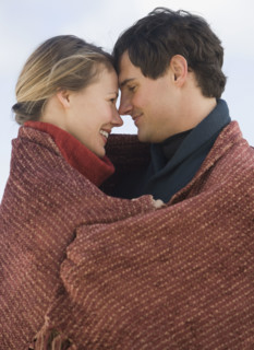 Couple wrapped in blanket.