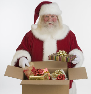Santa Claus packing gifts in box.
