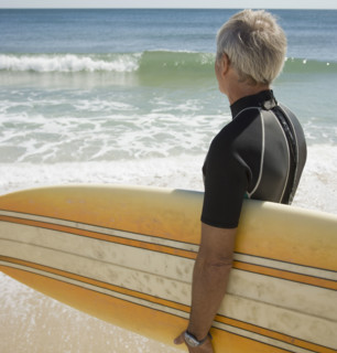 Man holding surfboard at beach.