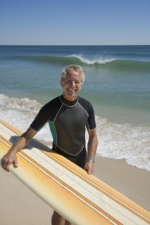Man holding surfboard at beach.