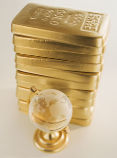 Globe next to stack of gold bars.