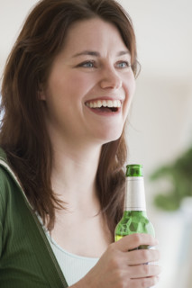 Woman holding bottle of beer.