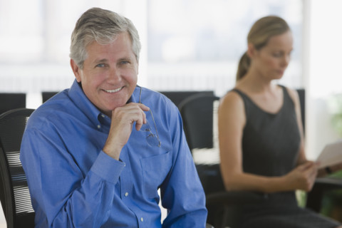 Businessman with businesswoman in background.