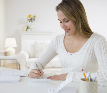 Woman writing at desk.